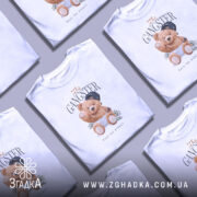 Футболка Ведмедик гангстер, біла, зображена на моделі з правого ракурсу, фон світло-сірий, принт з ведмедиком у кепці та золотих ланцюгах, що тримає гроші.