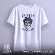 Футболка Veteran білого кольору, підвішена на вішалці, ракурс спереду, фон світло-сірий, принт з черепом у військовій касці та написом 'VETERAN' у верхній частині.