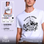 Футболка відповідь завжди чекає. Біла футболка на чоловікові, зображена в анфас, фон світло-фіолетовий. Принт з чорними елементами, що зображає гори, лижі та напис 'Чекає на вершині'.