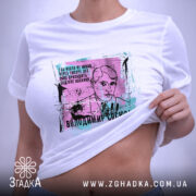 Футболка Володимир Сосюра, біла, зображена на плоскій поверхні, ракурс зверху, фон світло-сірий, принт з портретом Володимира Сосюри з кольоровими акцентами та текстом.
