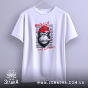 Футболка вулиця мої джунглі, біла, підвішена на вішалці, з принтом мавпи в червоній шапці, що курить, на фоні світло-сірого кольору.