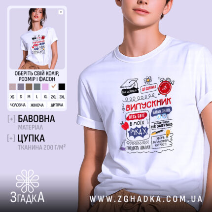 Футболка випускник білого кольору, зображена на молодій людині, яка позує з легким усмішкою. Принт на футболці містить текст 'ВИПУСКНИК' та інші елементи, виконані в червоному, чорному та синьому кольорах. Фон світло-фіолетовий, що підкреслює яскравість дизайну.