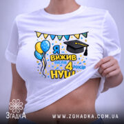 Футболка випускнику 4 класу, біла, на столі, з етикеткою, принт з написом 'Я вижив після 4 років НУШ', з ілюстраціями повітряних кульок і шапки випускника, яскраві кольори, святковий настрій.