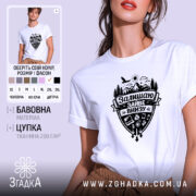 Футболка залишаю зайве внизу. Біла футболка на моделі, з коротким рукавом, з принтом чорного кольору, що зображає гори, ліс, сонце та різні предмети. Фон світло-фіолетовий, модель позує з легким усмішкою.