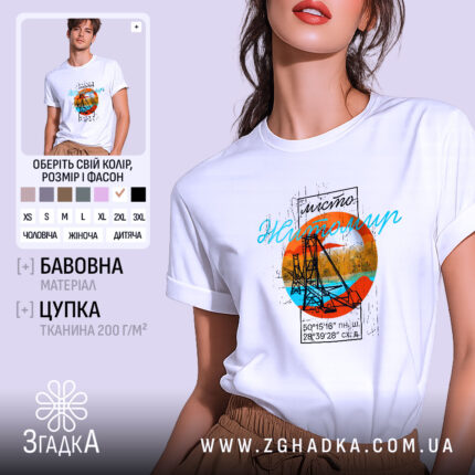 Футболка Житомир арт місто, біла, на моделі з легким ракурсом, фон пастельний, принт з оранжевим колом, синім текстом та зображенням мосту.
