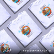 Футболка Житомир арт місто, біла, на моделі з легким ракурсом, фон пастельний, принт з оранжевим колом, синім текстом та зображенням мосту.