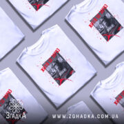 Футболка Життя це зараз, біла футболка на молодому чоловікові, зображення з ракурсу спереду, фон світло-фіолетовий, принт з чорно-білим шимпанзе, текстом червоного кольору та плямами червоного кольору.