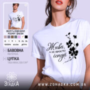 Футболка живи не існуй, біла, зображена з близького ракурсу, на фоні світло-сірого кольору, з чорним принтом, що містить напис 'Живи, а не просто існуй' та квітковий візерунок.