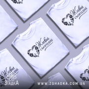 Футболка живи сьогодні, біла, зображена на моделі, ракурс спереду, фон світло-фіолетовий, принт чорного кольору з написом 'Живи сьогодні' у формі серця з квітами.