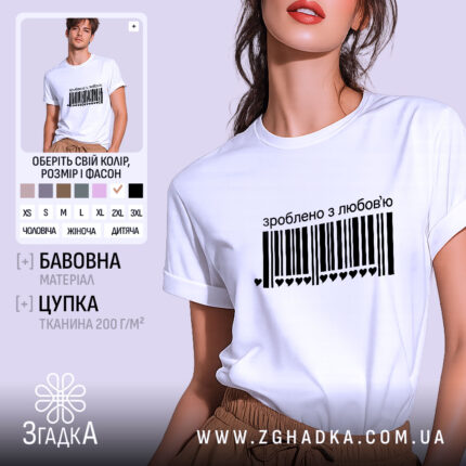 Футболка зроблено з любов’ю, біла, на моделі, з чорним принтом у вигляді штрих-коду та написом 'зроблено з любов’ю', фон світло-фіолетовий, модель з легким макіяжем та розпущеним волоссям.