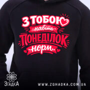 Худі на день закоханих, темно-синього кольору, з капюшоном. На передній частині розташований великий червоний принт з написом "З тобою навіть понеділок норм.". Видно деталі капюшона та манжетів, фон світлий.