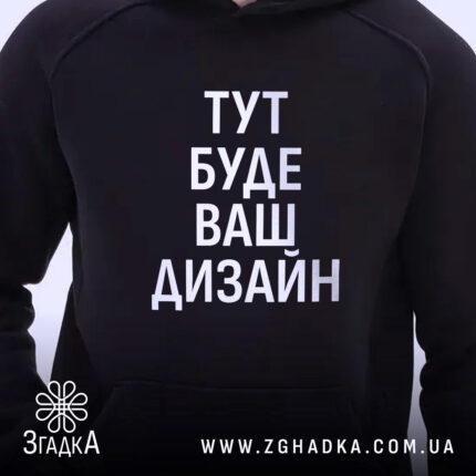 Худі з вашим дизайном, темно-синього кольору, з ракурсу спереду, на фоні світлий, великий принт з написом "ТУТ БУДЕ ВАШ ДИЗАЙН", капюшон, видно частину кишені-«кенгуру», манжети з еластичної тканини.
