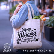 Шопер несу щастя і трохи продуктів — деталі тканини, ручок і швів крупним планом.