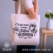 Шопер в цій сумці тільки гарні новини — шопер, крупний план принта на нейтральному фоні.