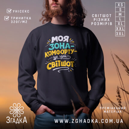Світшот моя зона комфорту, чорного кольору, з круглою горловиною, на моделі з бородою, фон з м'яким градієнтом, принт з написом яскравих кольорів, манжети та трикотажна резинка на поясі, фактура м'яка та приємна на дотик.