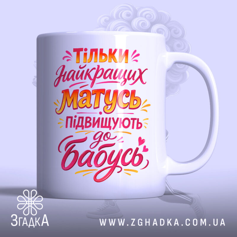 Чашка для майбутньої найкращої бабусі, біла, з яскравим принтом на фронтальній частині, текст виконаний у червоному та жовтому кольорах, з елементами декору у вигляді сердечок, ручка гладка, край рівний, глянцева поверхня, фон світло-фіолетовий.