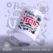 Чашка для найкращого тестя. Біла чашка з принтом 'Робота почекає ТЕСТЬ відпочиває', з ракурсу знизу. Фон світло-сірий з елементами графіки. Ручка стандартної форми, край рівний, поверхня глянцева.