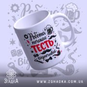 Чашка для найкращого тестя. Біла чашка з принтом 'Робота почекає ТЕСТЬ відпочиває', ракурс з боку. Фон світло-сірий з графічними елементами. Ручка стандартна, край рівний, поверхня глянцева.