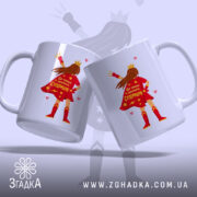 Чашка для Супермами, дві чашки, обидві білі, зображені з легким нахилом, на фоні світло-фіолетового кольору, з принтом супергероїні в червоному плащі, на якому написано 'Ця чашка належить Супермамі', ручки класичні, краї рівні, глянцеві.