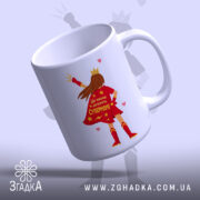Чашка для Супермами, біла, зображена з легким нахилом, на фоні світло-фіолетового кольору, з принтом супергероїні в червоному плащі, на якому написано 'Ця чашка належить Супермамі', ручка класична, край рівний, глянцевий.