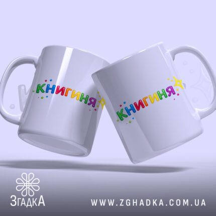 Чашка подарунок для книголюба, дві білих чашки з написом 'КНИГИНЯ' кольоровими літерами, ручки класичні, фон світло-фіолетовий, легкий блиск.