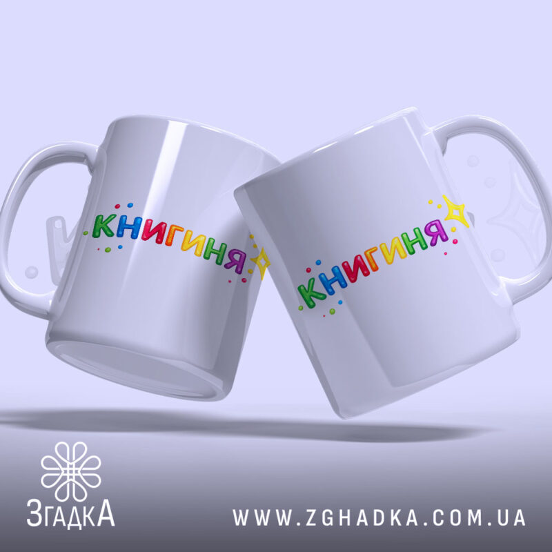 Чашка подарунок для книголюба, дві білих чашки з написом 'КНИГИНЯ' кольоровими літерами, ручки класичні, фон світло-фіолетовий, легкий блиск.