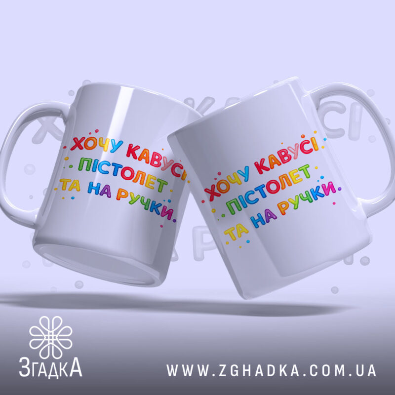 Чашка прикол хочу кавусі. Дві білосніжні чашки з однаковим принтом, на якому написано 'Хочу кавусі, пістолет та на ручці'. Принт яскравий, кольоровий, фон світло-сірий. Ручки чашок гладкі, краї рівні, поверхня глянцева.
