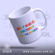 Чашка прикол хочу кавусі. Чашка білого кольору з яскравим принтом, на якому написано 'Хочу кавусі, пістолет та на ручці'. Принт виконаний у різнокольорових літерах, фон світло-сірий. Ручка гладка, край рівний, поверхня глянцева.