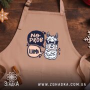 Фартух без проблем лама в окулярах, бежевий, ракурс зверху, фон дерев'яний, бренд.