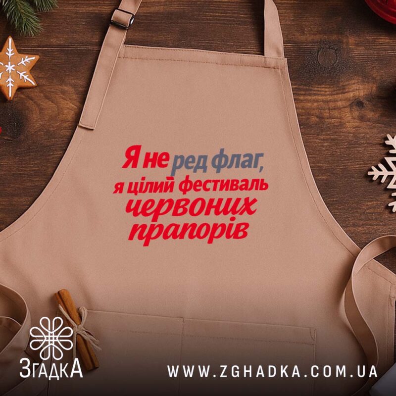 Фартух фестиваль червоних прапорів, бежевий, на дерев'яному фоні, текст яскравий, бренд Згадка.