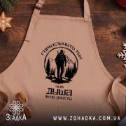 Фартух гори кличуть, бежевий на дерев'яному фоні, бренд Згадка.