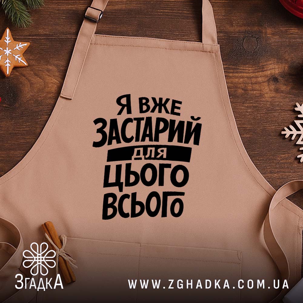 Фартух я вже застарий для цього всього, бежевий, на дерев'яному фоні, бренд.