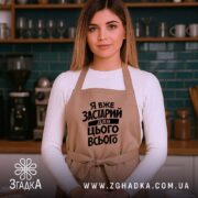 Фартух я вже застарий для цього всього, бежевий, на жінці, кухня, бренд.