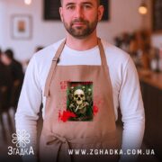 Фартух клуб безсмертних з черепами, бежевий, на чоловікові, кафе в фоні, бренд.