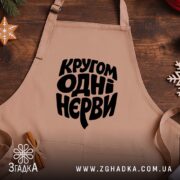 Фартух кругом одні нєрви, бежевий на дерев'яному фоні, принт чорний, бренд Згадка.