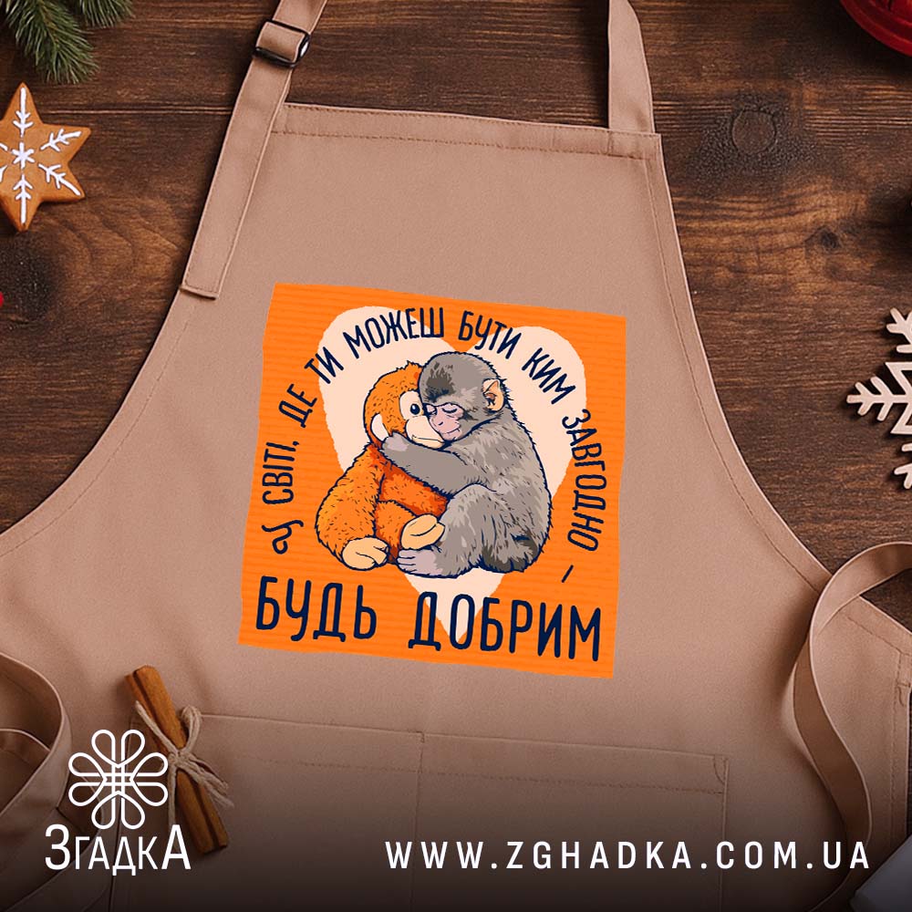 Фартух мавпочка Панч будь добрим, бежевий фон, принт на дерев'яному столі, бренд.