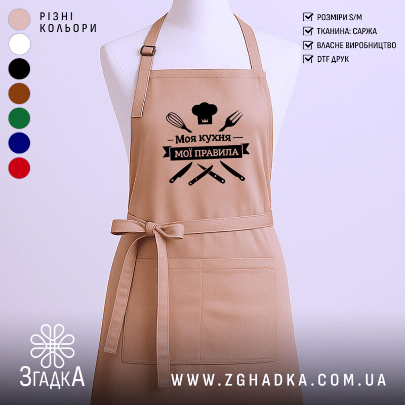 Фартух моя кухня мої правила. Фартух бежевого кольору, зображений з фронтального ракурсу на манекені. Фон світлий, з простим дизайном. Принт чорного кольору з написом 'Моя кухня мої правила' та зображеннями кухонних інструментів.