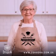 Фартух моя кухня мої правила. Фартух бежевого кольору, зображений з фронтального ракурсу на манекені. Фон світлий, з простим дизайном. Принт чорного кольору з написом 'Моя кухня мої правила' та зображеннями кухонних інструментів.