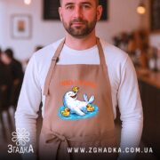 Фартух морський котик і качечки, бежевий, на чоловікові, кафе на фоні, бренд.