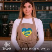 Фартух на своїй землі патріотичний принт, бежевий, на моделі в кухні, бренд.