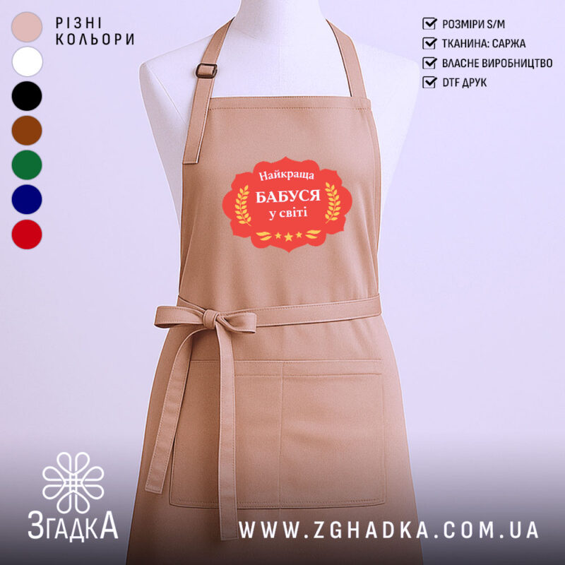Фартух найкраща бабуся, бежевого кольору, зображений на манекені, фон однотонний, принт з написом 'Найкраща Бабуся у світі' в червоній рамці з зірками.