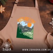 Фартух поведи мене в гори подарунок, бежевий на дерев'яному фоні, бренд Згадка.