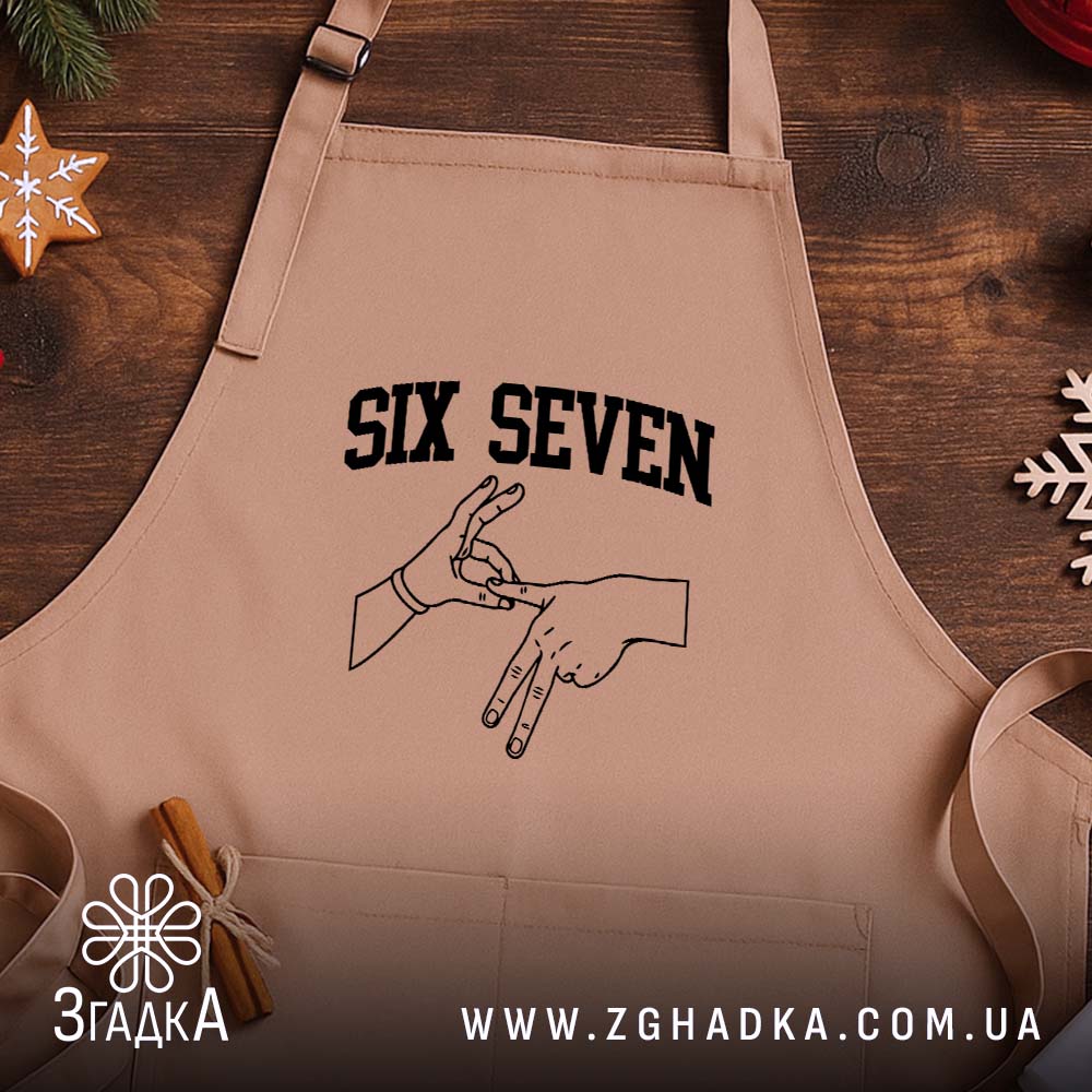 Фартух six seven жест руками, бежевий, на дерев'яному фоні, бренд Згадка.