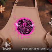 Фартух сильна і з характером, бежевий, з принтом на дерев'яному фоні, бренд.