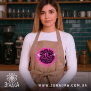 Фартух сильна і з характером, бежевий, на моделі в кухні, бренд Згадка.