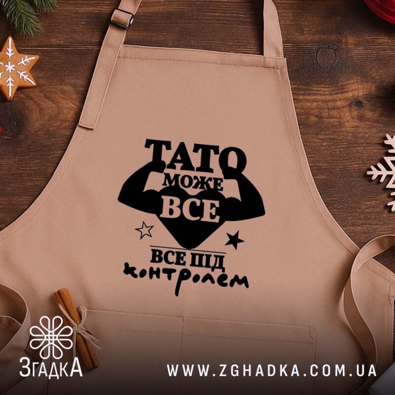 Фартух Тато може все, бежевий, на дерев'яному фоні, бренд Згадка.