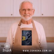 Фартух тиша моя зброя, бежевий, на літньому чоловікові в кухні, з принтом.