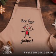 Фартух все буде добре, бежевий колір, на дерев'яному фоні, бренд Згадка.