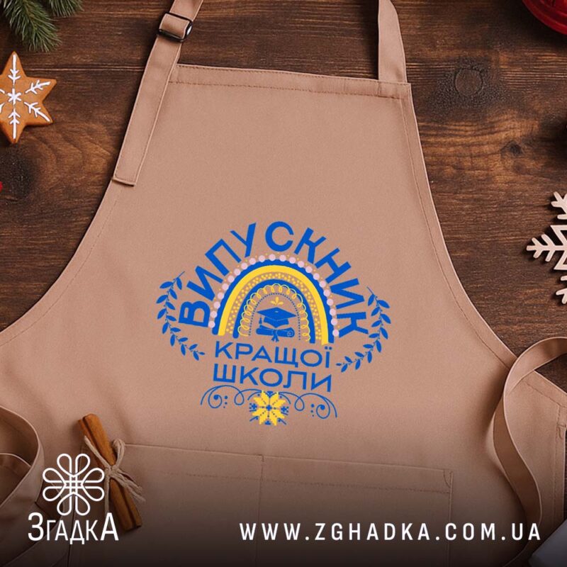 Фартух випускник кращої школи, бежевий, на дерев'яному фоні, бренд Згадка.