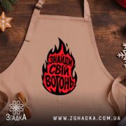 Фартух знайди свій вогонь, бежевий фон, на дерев'яному столі, бренд Згадка.